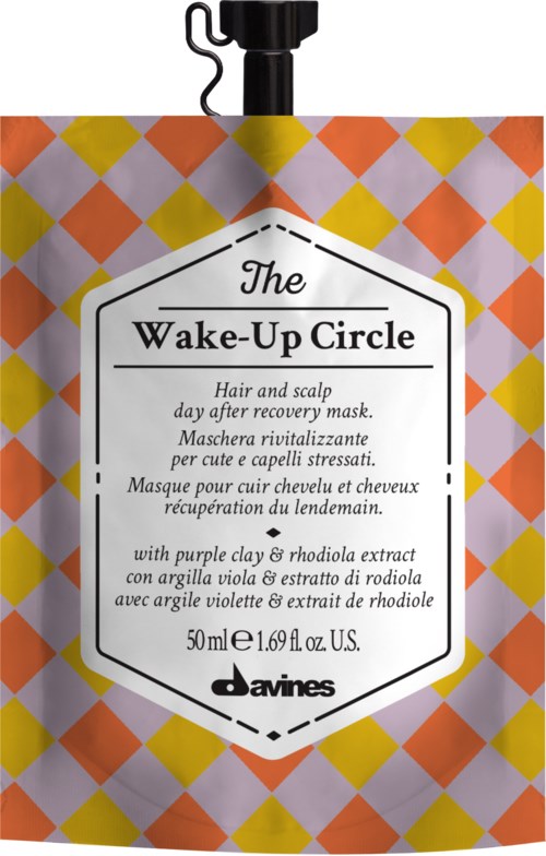 A colorful, diamond-patterned package for a hair mask, with black top, text describing the product and ingredients.