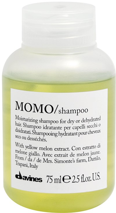 Vit flaska med Momo-schampo med gulgrön vätska och en etikett som beskriver att det innehåller melonextrakt.