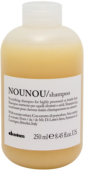 En beige schampoflaska med vit etikett som visar varumärket Nounou, 250 ml volym, och nämner tomatextrakt.