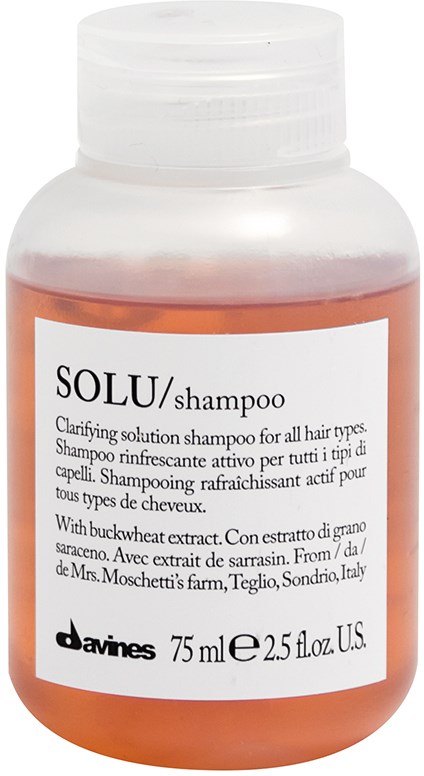 En flaska Solu-schampo med vit lock och en vit etikett med produktdetaljer.