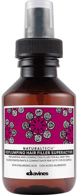 En liten brun flaska med svart spraytop, märkt för hårbehandling med rosa och lila design och text.