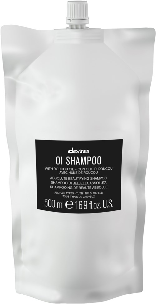 En vit påfyllningspåse med en svart etikett, innehåller 500 ml oljeschampo, har en vridkork upptill.