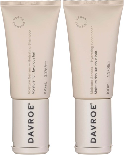 Zwei beigehaarige Pflege-Tuben mit dem Label Davroe, eine für Shampoo und die andere für Conditioner, stehen aufrecht.