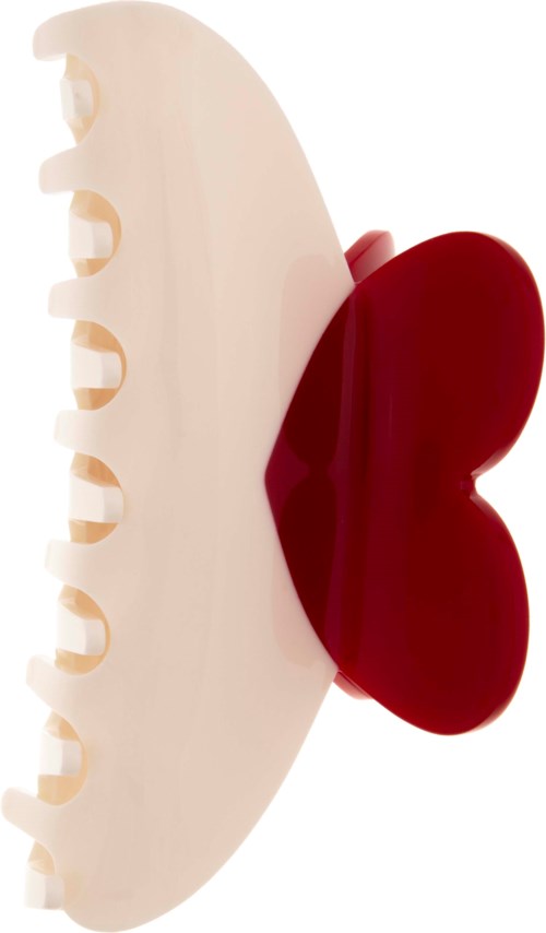 En vit plastikhårklämma med en röd fjärilsformad dekoration på ena sidan.