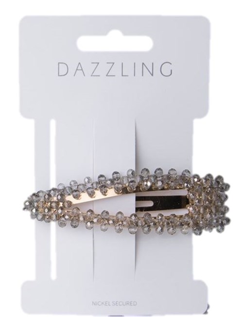 En glittrande hårklämma med gnistrande stenar på ett vitt kort märkt "Dazzling".