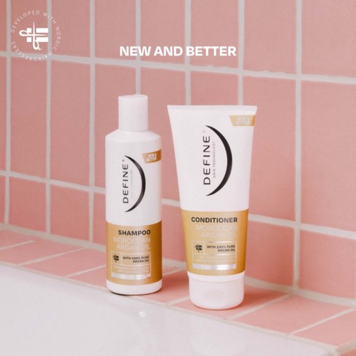 Twee haarproducten op roze betegelde muur, gelabeld Define Shampoo en Conditioner met Arganolie.