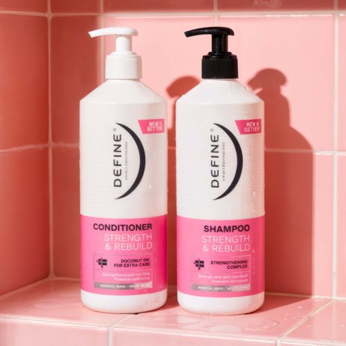 Two bottles of hair care products, conditioner and shampoo, with pink and white labels on a pink tiled shelf.