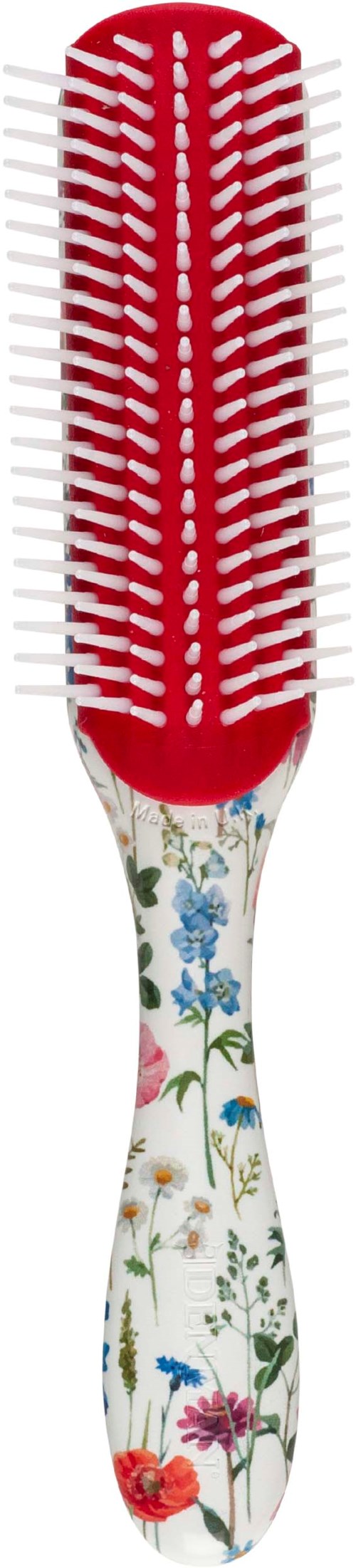 Eine Haarbürste mit Blumenmuster am Griff und rotem und weißem Kamm.