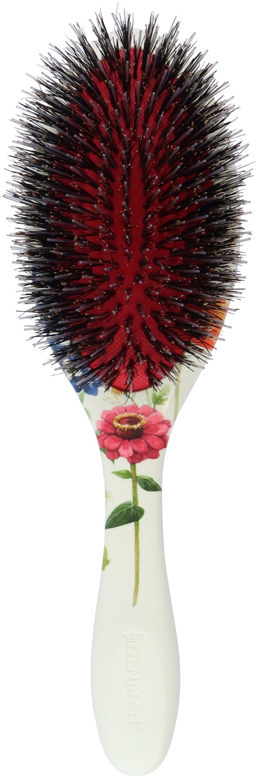 Eine Haarbürste mit weißem Griff und Blumenmuster, mit schwarzen und roten Borsten.