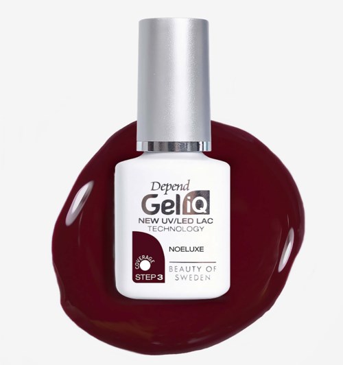 Nagellacksgeléflaska med silverlock på en glänsande röd yta.