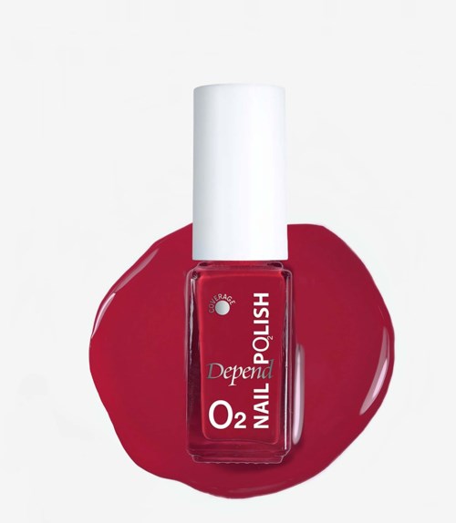 A red nail polish bottle with a white cap, lying on a small puddle of matching red nail polish.