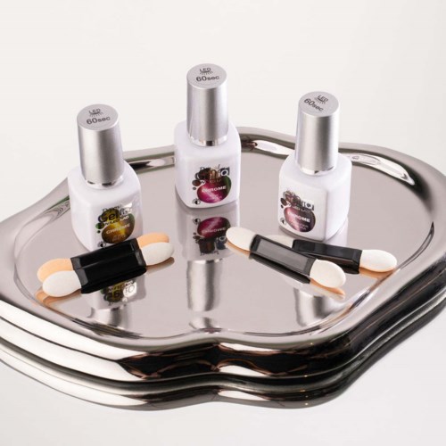 Three bottles and two capsules placed on a reflective tray, with colorful labels and metallic caps.