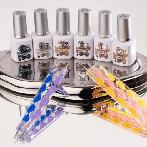 Nail polish bottles are lined up on a shiny surface with colorful nail brushes in front.