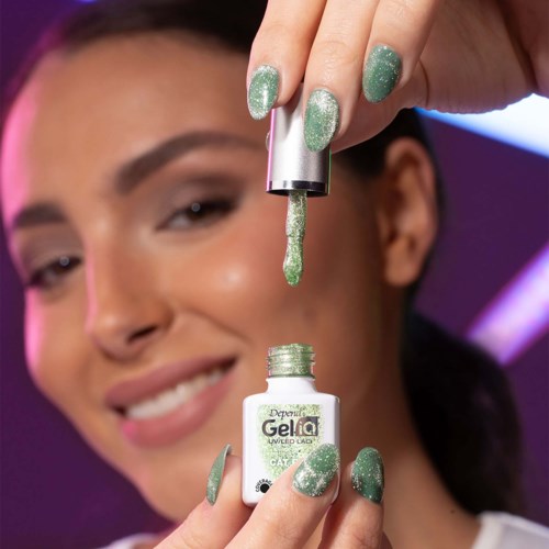 Een vrouw brengt glanzende groene gelnagellak aan, glimlachend met een close-up van haar gezicht en handen.