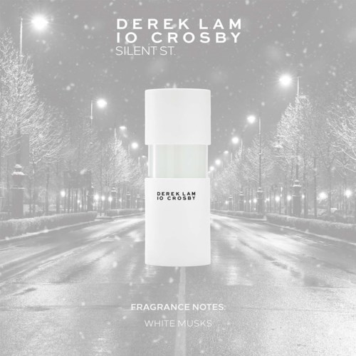 A white perfume bottle on a snowy city street at night, with text about the fragrance notes and creators.