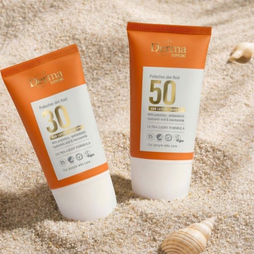 Two sunscreen tubes labeled 30 and 50 are on sand with a seashell nearby.