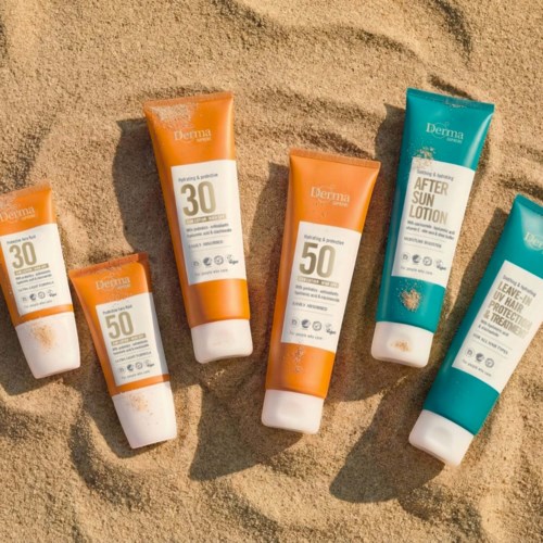 Six sunscreen tubes, some with SPF 30 and 50, placed on sand. They are from the brand Derma.