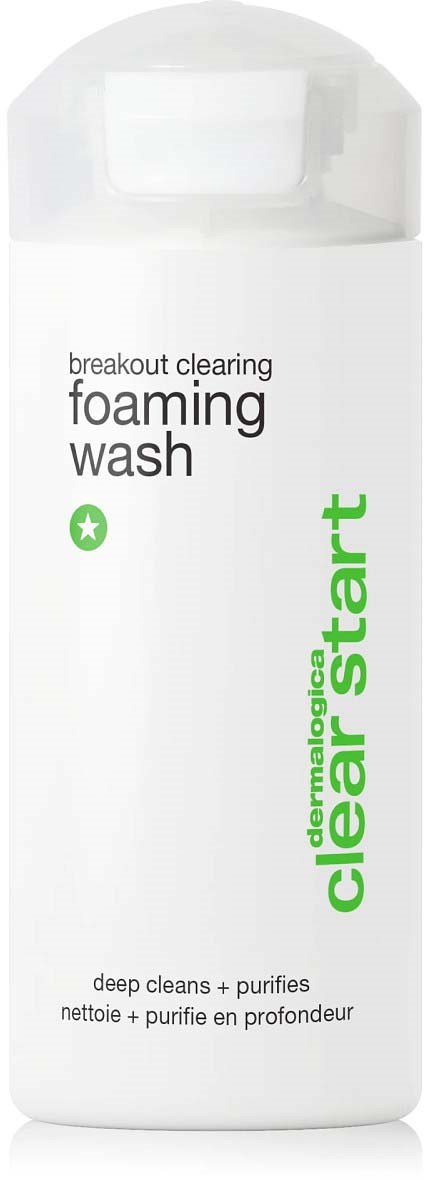 Een witte fles met groene en zwarte tekst voor een schuimende reinigingsmiddel, gelabeld als breakout clearing en dermatologist clear start.