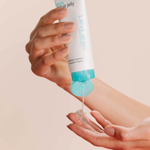 Een hand knijpt in een tube Clear Start Aqua Jelly; gel loopt op de handpalm van de andere hand.