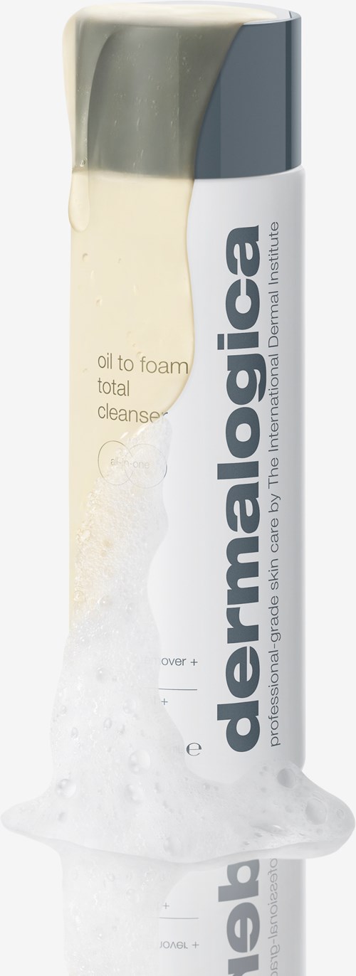 Een witte en grijze fles giet witte schuim, gemerkt 'dermalogica' en 'oil to foam total cleanse'.