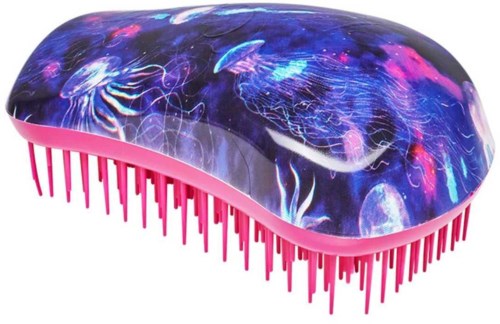 A hairbrush with a galaxy design on top and pink bristles.