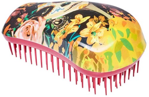 A hairbrush with a colorful floral and animal print, pink bristles, and a rounded shape.