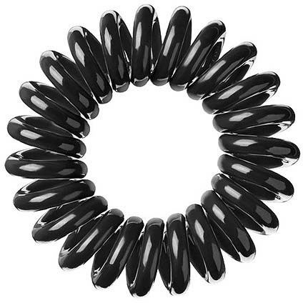 A circular arrangement of shiny black oval hair ties or bands with a hollow center.