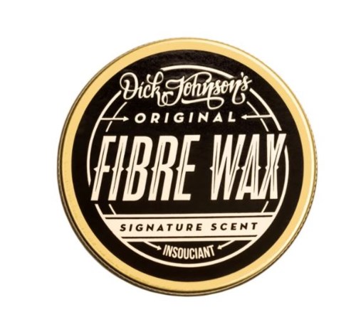 A round logo with black, white, and gold colors, showing brand name and scent description for fibre wax.