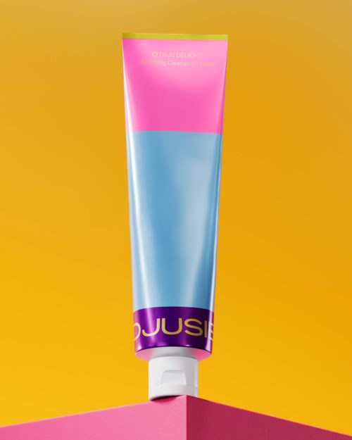 Eine bunte Tube mit Pink, Blau und Lila auf einem gelben Hintergrund, wahrscheinlich ein Kosmetik- oder Hautpflegeprodukt.