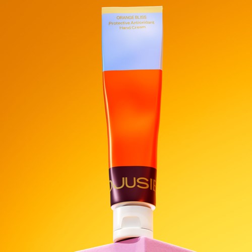 Eine Tube Handcreme mit orange und lila Farben, beschriftet 'Orange Bliss' und 'Protective Antioxidant Hand Cream.'