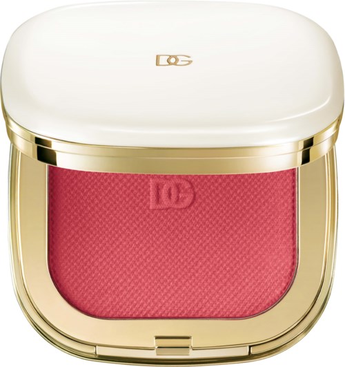 A compact makeup case with a white lid, gold trim, and a red blush inside.