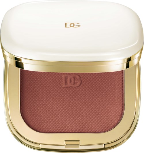 A compact makeup case with a gold trim and a pinkish blush inside.
