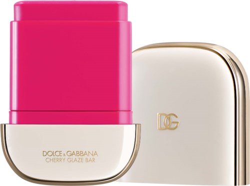 A pink lipstick and a white case with gold accents and a logo.