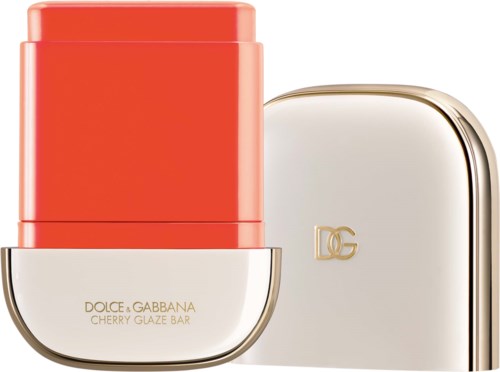 Ein Lippenstift in rotem Gehäuse mit weißer Basis, mit der Aufschrift Dolce & Gabbana Cherry Glaze Bar, neben einer weißen Box mit Gold DG-Logo.