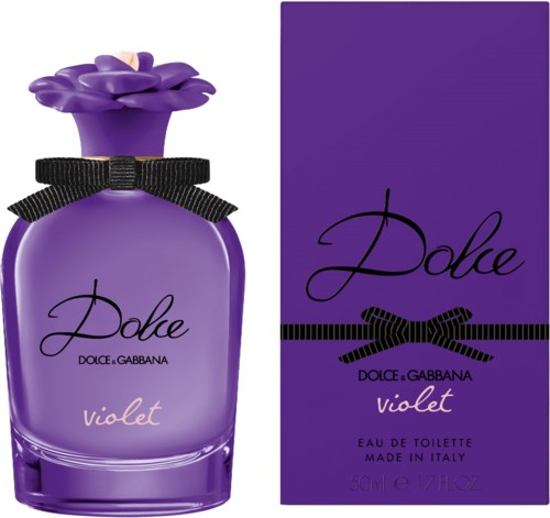 Violetti hajuvesipullo, jossa on kukkainen kansi ja musta nauha, vieressä samanlainen violetti rasia.