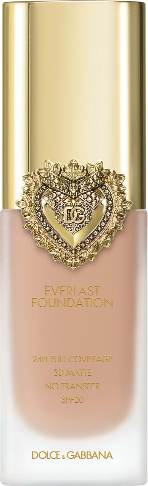 A foundation bottle with a gold cap, pink base, and a heart-shaped jeweled emblem, labeled Dolce & Gabbana.