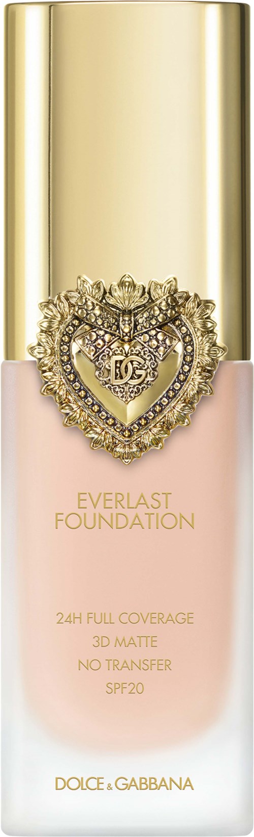 A foundation bottle with a gold cap, pink body, and a decorative heart emblem. It has labels about coverage and SPF.