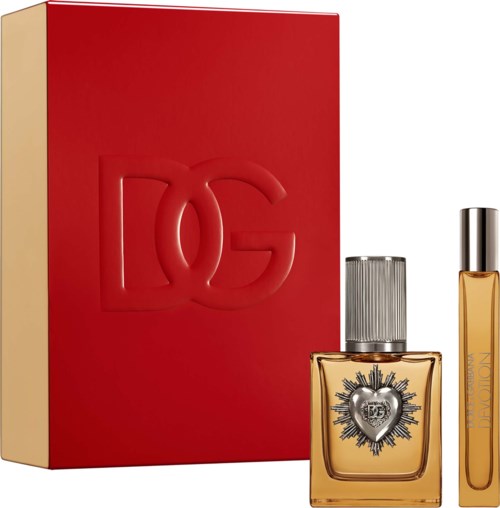 A perfume bottle with a black and silver cap and a heart-shaped emblem, next to a red gift box with a large logo.