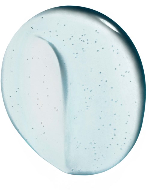 A pale, oval-shaped tablet with small black specks and a curved line dividing it in half.