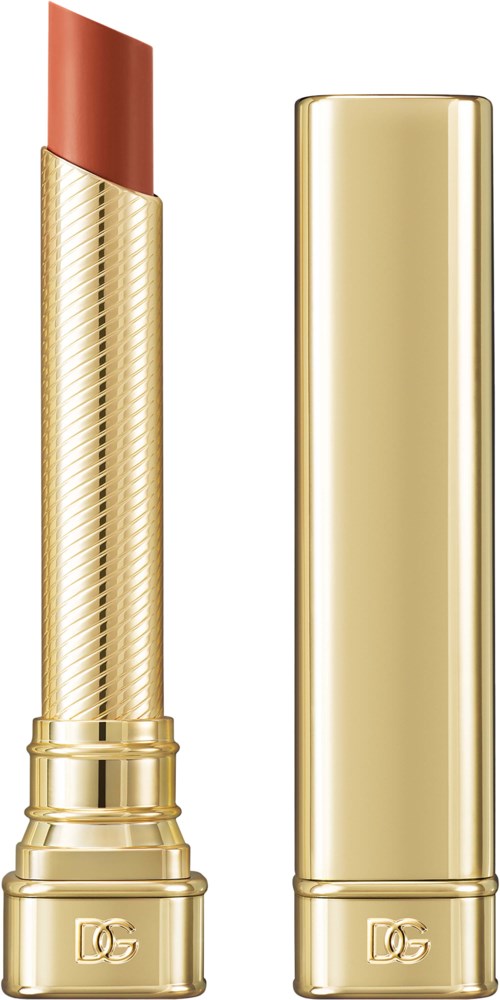 A gold lipstick tube with a partially twisted lipstick showing a nude color.