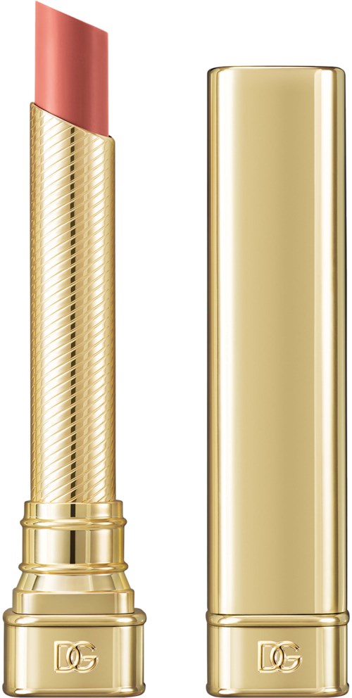 A gold lipstick tube with a peach-colored lipstick inside, and the cap beside it.