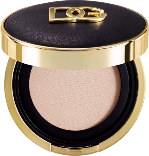 Ein luxuriöser Make-up-Compact mit schwarzem Deckel, goldfarbenen Kanten und beigefarbenem Puder.