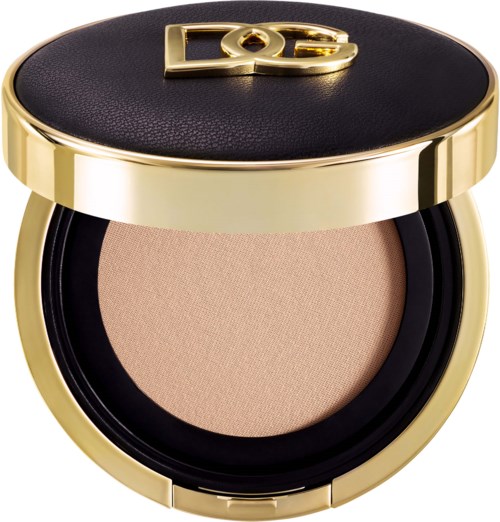 Ein runder Make-up-Deckel mit schwarzem Deckel und goldener Umrandung, enthält hellbeiges Puder. Auf dem Deckel ist ein Logo.