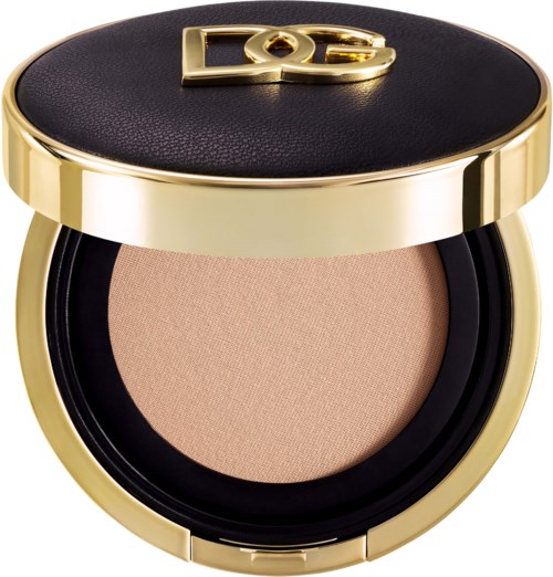 Ein kleines Make-up-Produkt mit schwarzem und goldenem Deckel, enthält beiges Puder.