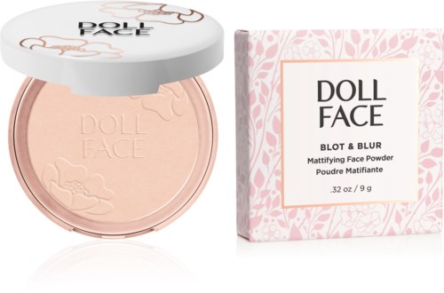 Ein Kompaktpuder in einer runden Dose mit Blumenmuster und einer rosa Verpackung, mit "Doll Face"beschriftet.