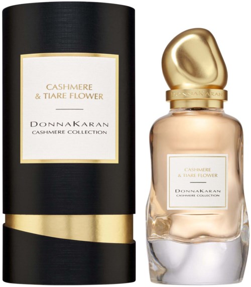 Een parfumbottle met een gouden dop en een zwarte doos, beide gemarkeerd 'Cashmere & Tiare Flower' van Donnakaran.