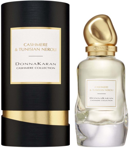 Een parfumsfles met een gouden dop en label, naast een zwart en goudkleurige cilindrische doos, beiden gelabeld 'Cashmere & Tunisian Neroli'.