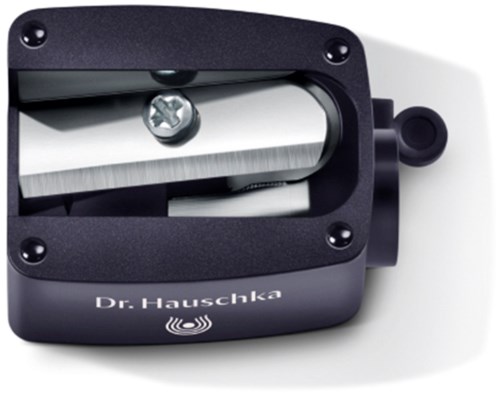 Een zwart apparaat met een metalen rail, schroef en een ronde afstellknop, gemarkeerd "Dr. Hauschka."