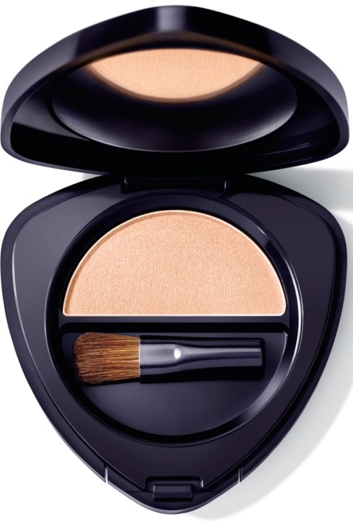 En liten sminkask innehåller beige puder och en liten borste, med locket öppet som visar produkterna.