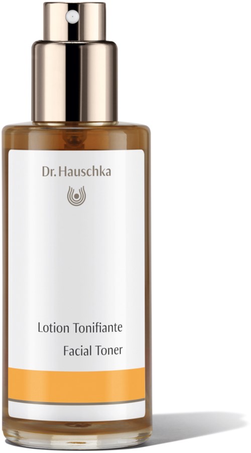 A skincare bottle labeled 'Dr. Hauschka', with a gold-cap and white label, labeled 'Facial Toner'.